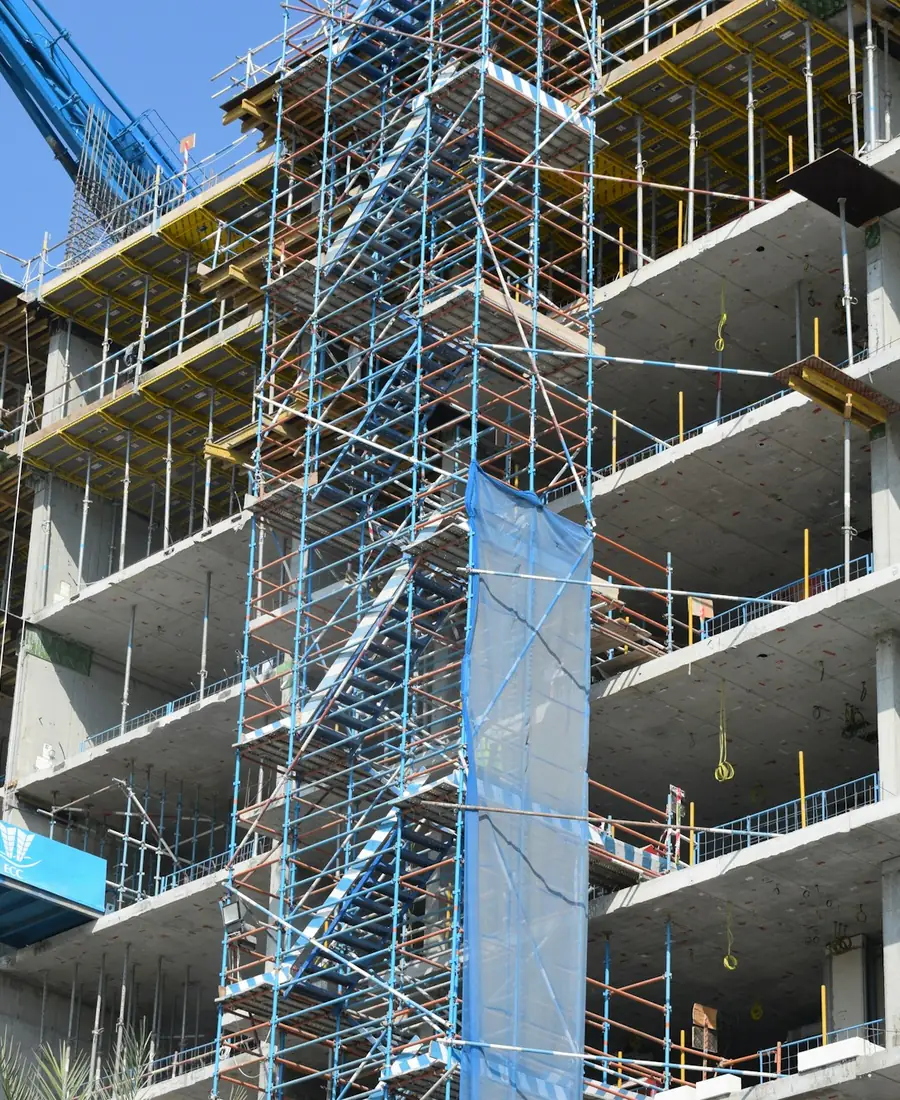 Multi-storey building under construction with scaffolding and a crane